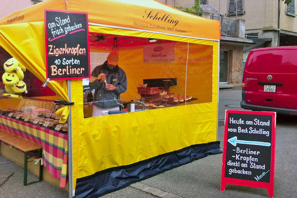 Ein Bäcker nutzt ein Street-Food-Zelt von Pro-Tent, um frische Berliner zuzubereiten.